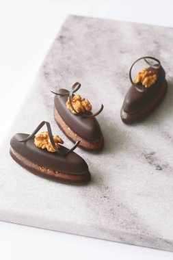 Ceviz ve çikolata sarmalı, açık mermer tahtada, beyaz arka planda, Praline 'li çikolatalı kurabiye..