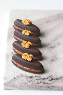 Ceviz ve çikolata sarmalı, açık mermer tahtada, beyaz arka planda, Praline 'li çikolatalı kurabiye..