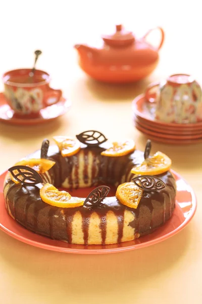 Bolo de mármore laranja de chocolate com esmalte de chocolate e fatias de laranja caramelizadas — Fotografia de Stock