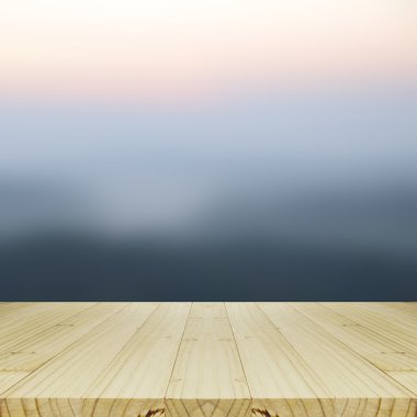 Ahşap masa ve bulanık gündoğumu arka plan.