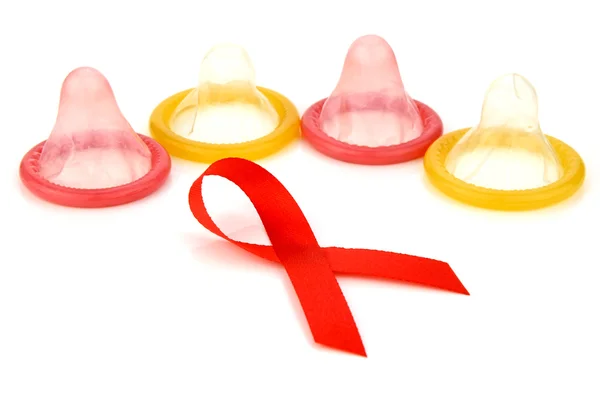 Знак червоною стрічкою з латексними презервативами фоном. — стокове фото