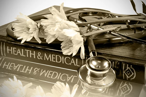 Стетоскоп и медицинский учебник на белом фоне с вырезкой . — стоковое фото