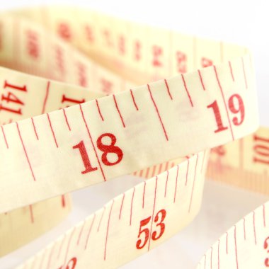 Bel ve kilo kontrolü kavramı beyaz arka plan üzerinde şerit metre.