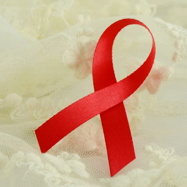 世界艾滋病日红丝带在软奶油背景上签名。艾滋病-艾滋病运动的标志. — 图库照片