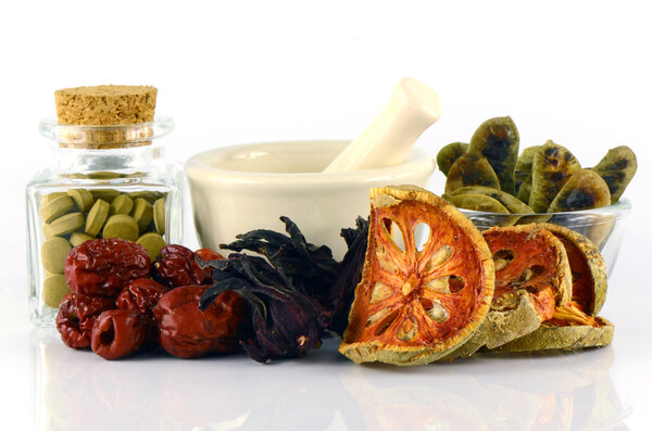 Herbal Medicine tablet and dried herbs.