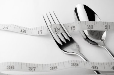 Mezura, çatal ve kaşık bel ve kilo kontrolü kavramı ile diyet kontrolü.
