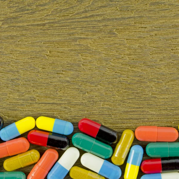 Kleurrijke orale medicatie in harde gelatine Capsules op Vintage houten achtergrond. — Stockfoto