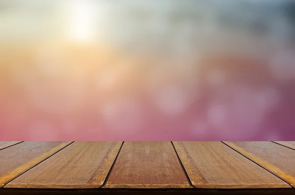 Rozmazané pozadí slunce, ranní světlo s dřevěný stůl. — Stock fotografie