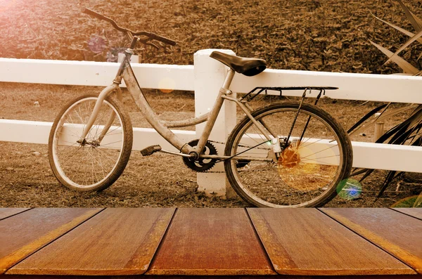 木製のテーブルと夕方の明るい背景で古い自転車. — ストック写真