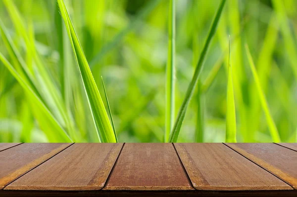 Grüner Glashintergrund mit Holztisch. — Stockfoto