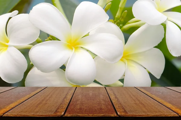 Leerer Holztisch mit Frangipani-Hintergrund. — Stockfoto