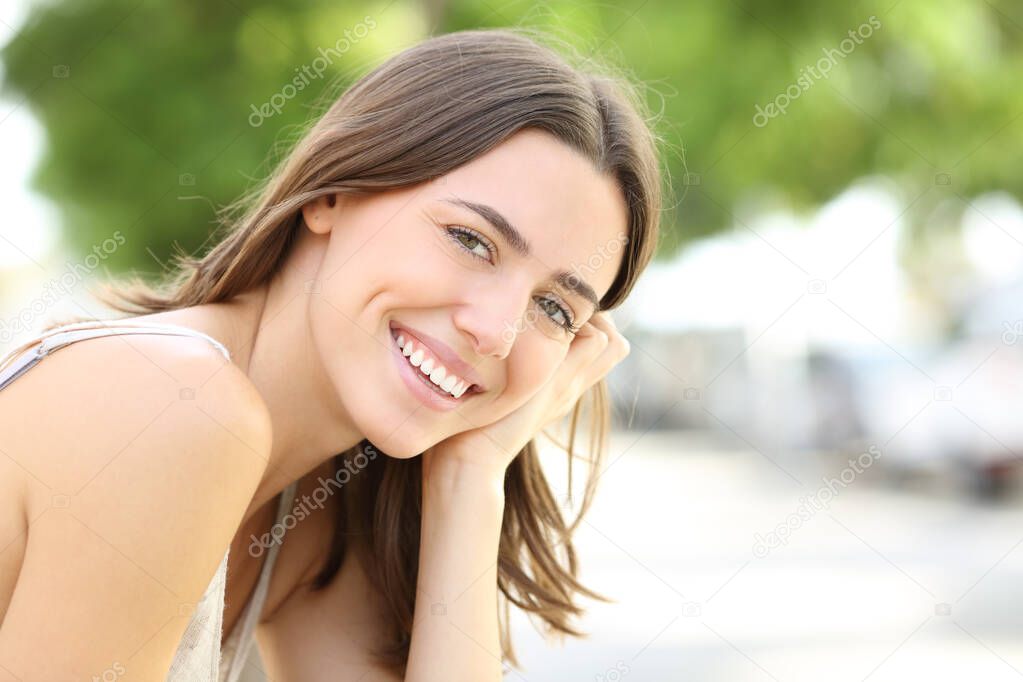 Happy woman with perfect smile looks at camera in the street