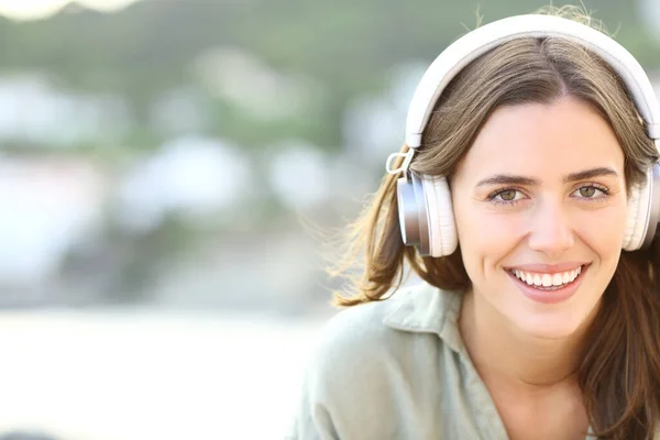 Kulaklık Takan Müzik Dinleyen Kumsalda Kameraya Bakan Mutlu Bir Kadının — Stok fotoğraf