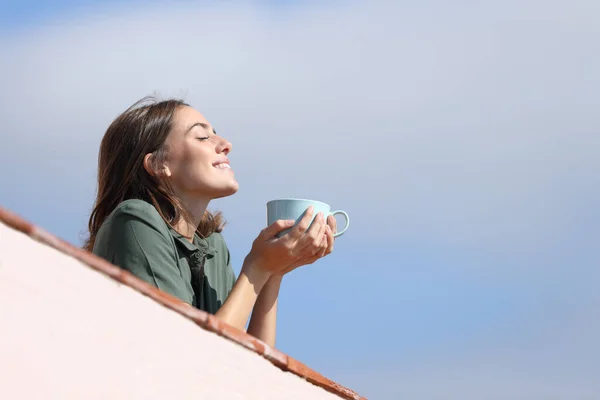 幸せな女性のプロフィールバルコニーから新鮮な空気を呼吸するコーヒーを飲む晴れた日 — ストック写真