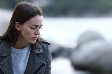 Üzgün kadın, kumsalda tek başına oturmaktan şikayetçi.