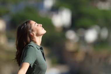 Bir dağ kasabasında temiz hava soluyan bir kadının profili.