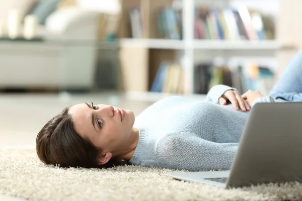 Pensive Žena Vedle Notebooku Dívá Pryč Ležící Podlaze Doma — Stock fotografie