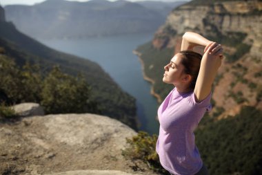 Rahatlamış koşucu dağdaki bir uçurumun tepesinde kol kola koşuyor.