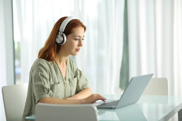 Konzentrierte Frau Mit Drahtlosen Kopfhörern Checkt Laptop Hause — Stockfoto