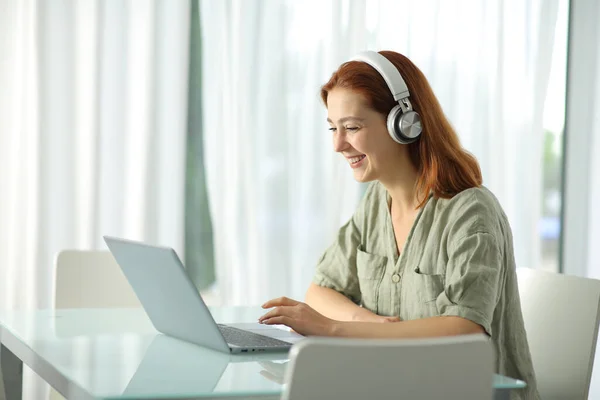 Mujer Feliz Con Auriculares Inalámbricos Que Comprueban Portátil Casa —  Fotos de Stock