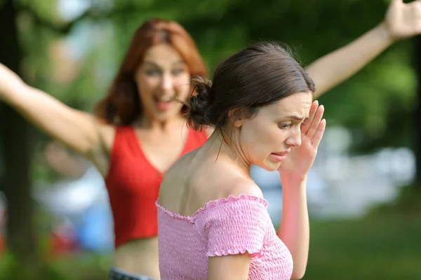 ストレスの多い女性を避けるために友人を満たすために公園を歩く — ストック写真