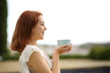 Bahçede manzaralar seyreden mutlu bir kadının portresi.