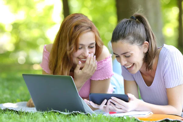 Estudantes Felizes Assistindo Vídeos Line Telefone Inteligente Rindo Deitado Grama — Fotografia de Stock