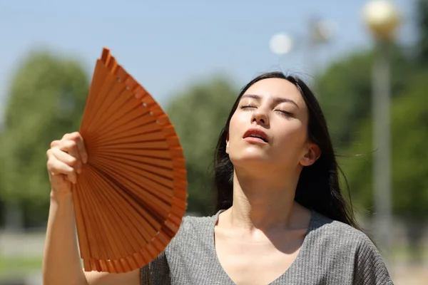 Stressed asian woman fanning suffering heatstroke in the street a warm summer day