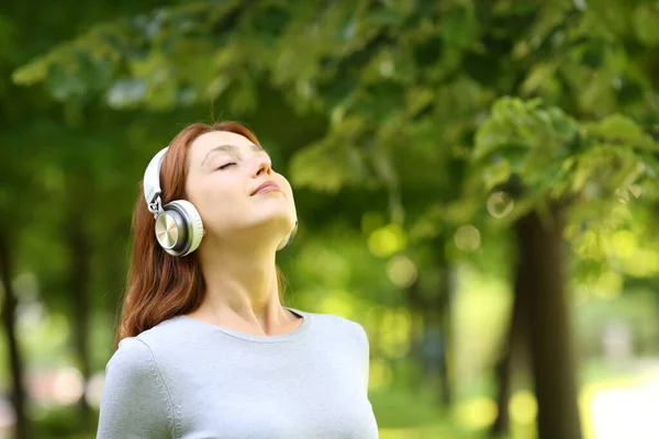 Kulaklık Takan Rahat Bir Kadın Parkta Meditasyon Yapıyor — Stok fotoğraf