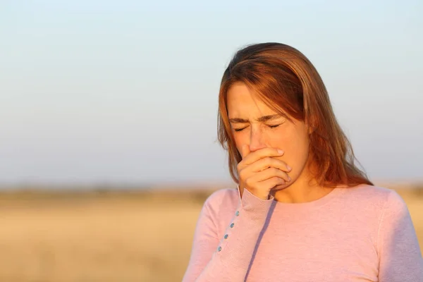 日落时生病的女人在收割的田里咳嗽 — 图库照片