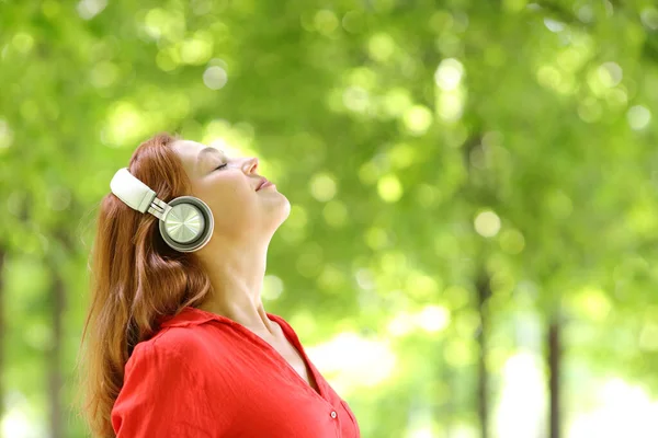 Yeşil Bir Parkta Meditasyon Yapan Kablosuz Kulaklık Takan Bir Kadının — Stok fotoğraf