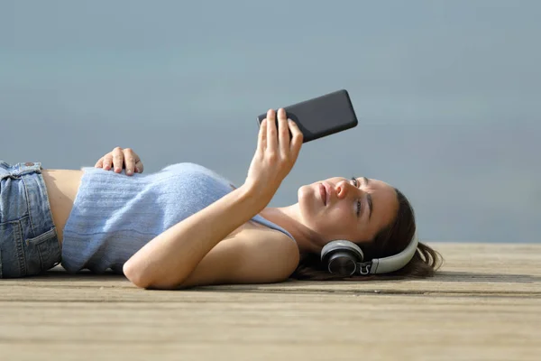 Serious Woman Lying Pier Listening Music Smart Phone — Stock Photo, Image