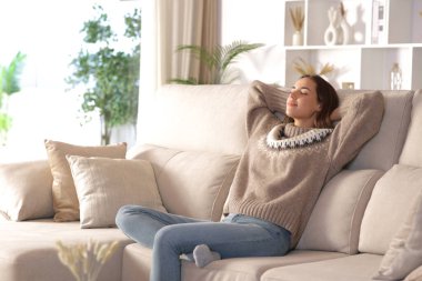 Kışın evdeki kanepede dinlenen bir kadın. 