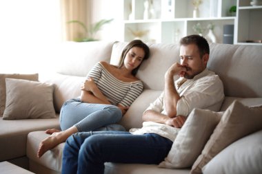 Üzgün adam evdeki kanepede oturan endişeli kız arkadaşının yanında şikayet ediyor.