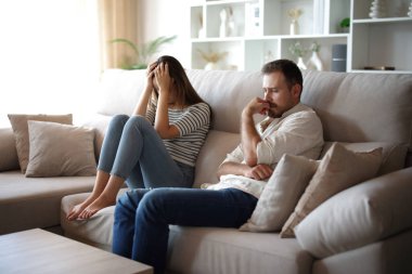 Üzgün çift, evdeki koltukta oturup tartıştıktan sonra şikayet ediyor.