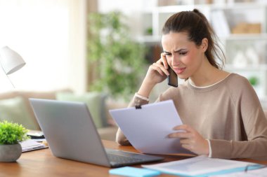 Kafası karışık bir serbest meslek, telefonda evde çalıştığına dair konuşuyor.