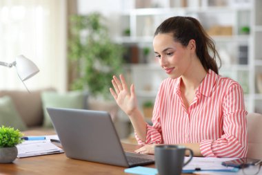 Evde çalışan dizüstü bilgisayarla arama ve selamlama yaparak serbest meslek