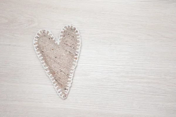 Corazón de lino hecho a sí mismo sobre fondo de madera — Foto de Stock