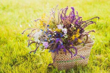 Flowers in the basket on the grass clipart