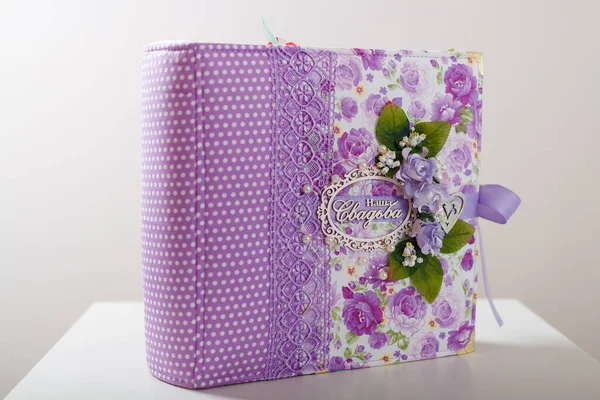 Fabric covered weddig scrapbook album with purple lace, flowers and inscription in Russian reads - Our Wedding.