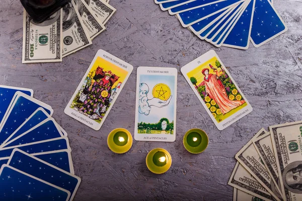 Kehanet kartları para ve yeşil mumlarla aynı hizada. Gizem, astroloji, falcılık, inanç ve zenginlik kavramı. 