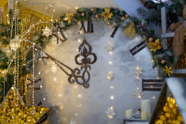 Noel zamanı konsepti. Yapay ve ahşap köknar ağaçları ve parlak altın yıldızlı büyük dekoratif saat. Gece yarısına dakikalar var. Mutlu yıllar..