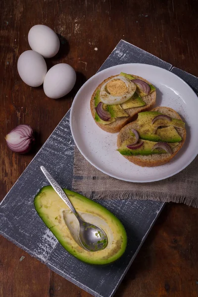 Dos Sándwiches Con Aguacate Huevos Cocidos Cebollas Rojas Plato Blanco — Foto de Stock