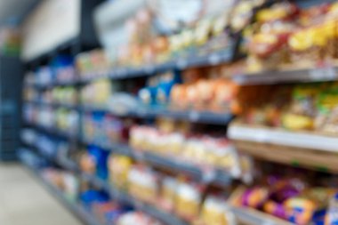 Süpermarketin iç mekanının odaklanmamış görüntüsü. Bulanık hipermarket, alışveriş merkezi ya da alışveriş merkezi geçmişi. Market departmanının sıraları ve rafları.