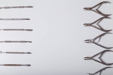 Manikür, pedikür ekipmanları, beyaz arka plan, üst manzara. Güvenli hijyen, güzellik ve el bakımı için dezenfekte edilmiş aletler. Üst Manzara. Boşluğu kopyala.