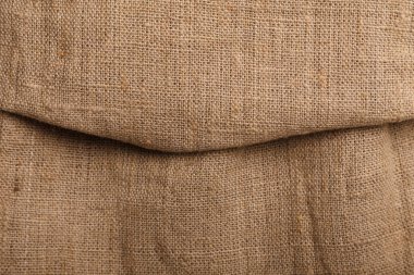 Katlanmış kahverengi kumaşın çuval bezi dokusu, arkaplan veya arkaplan.