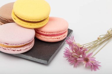 Beyaz arka planda gri hasırlı renkli kurabiyeler. Tatlı fırın, kopyalama alanı.