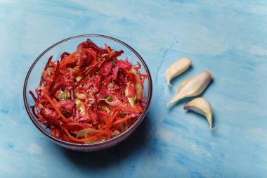 Fırça adında bir kase salata. Pancar, havuç ve lahanayla ince şeritler halinde kesilmiş sarımsak ve ahşap kaplama. Vejetaryen, organik, sağlıklı yiyecekler, diyet, beslenme. Üst görünüm, alanı kopyala.