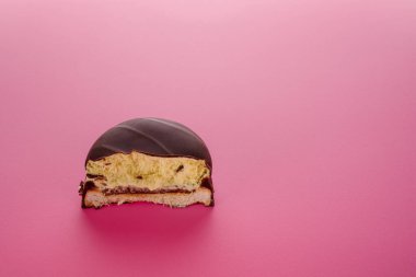 Çikolata jöleli bisküvinin yarısı ya da pembe arka planda reçelli krema. Tatlı, sağlıksız atıştırmalıklar. Boşluğu kopyala.