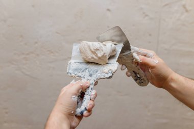 Duvarda macun kullanan spatula kullanan erkek eller, tadilat yapan inşaatçılar..